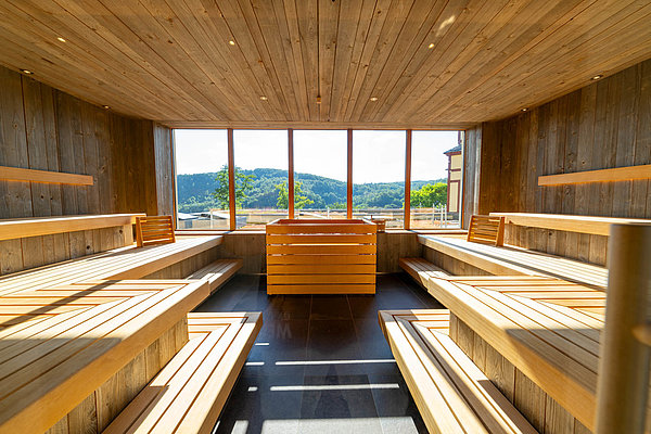 Moderne Sauna in hellem Holz im Hotel & Spa Suiten FreiWerk mit großem Fenster  für einen beeindruckenden Panoramablick.