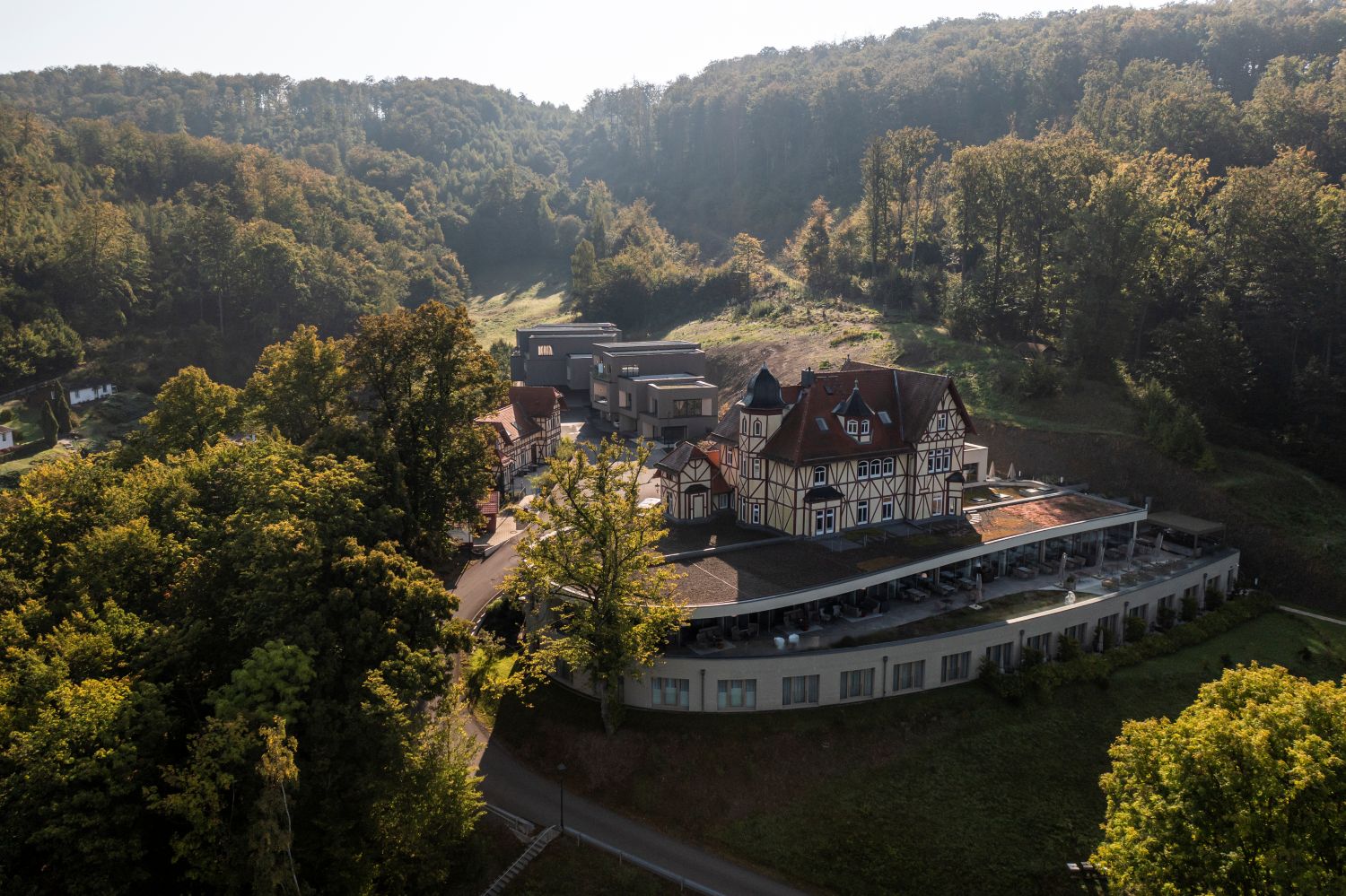 Das Hotel & Spa Suiten FreiWerk in Herbststimmung belichtet und umgeben von den Farben der Bäume im Herbst.